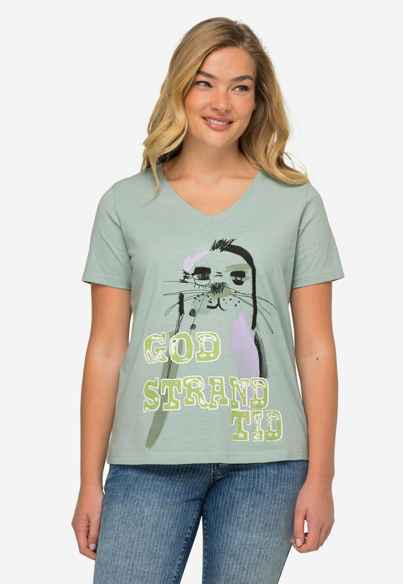 Camiseta de algodón verde claro con escote en V, que presenta una ilustración de un sello y un texto en negrita "GOD STRANDTID" en blanco y verde claro.
