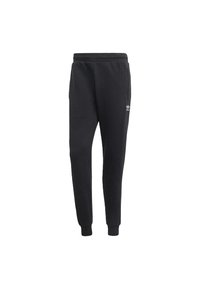 Black sweatpants with a tapered design, made of soft fabric. Features an elastic waistband and cuffed ankles. Displays a small white logo.