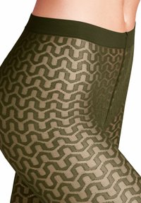 Collants opaques vert olive avec un motif en zigzag texturé. La taille est élastique et le matériau a une finition lisse.