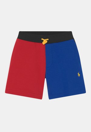 Calções de algodão vermelhos e azuis com uma cintura preta e cordão de ajuste amarelo. Apresentam um destaque de logotipo amarelo no lado azul.