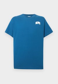 Μπλε βαμβακερό t-shirt με κοντά μανίκια, στρογγυλή λαιμόκοψη και λευκό λογότυπο στο αριστερό στήθος. Απαλή υφή, άνετη εφαρμογή.
