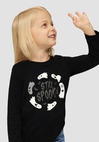 Zwarte langsl sleeve shirt met een cirkelontwerp, wit ghost graphics en de tekst "STAY SPOOK!" in het grijs, gemaakt van zachte stof.