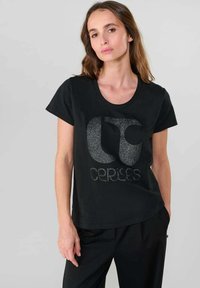 Sort T-shirt med rund halsudskæring og korte ærmer. Designet inkluderer et glitrende logo og tekst foran. Stoffet ser glat ud.