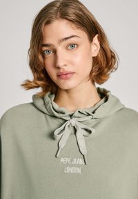 Felpa verde realizzata in morbido tessuto, con cappuccio regolabile e logo ricamato "PEPE JEANS LONDON" in bianco sul petto.