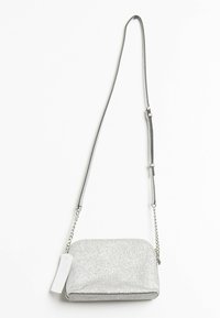 Silver glitter crossbody bag with a metallic texture, rectangular shape, chain and fabric strap, and a white tag attached.