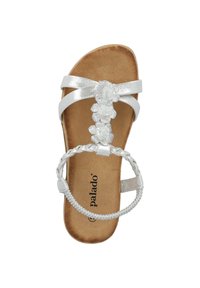 Sandal bianco con cinturini metallici, decorazioni floreali e cinturino alla caviglia intrecciato. Soletta morbida marrone con logo. Design a suola piatta.