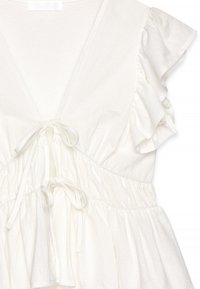 Witte katoenen jurk met een diepe V-hals, trekkoord in de taille en gerimpelde korte mouwen. Zachte textuur met een geplooide taille detail.