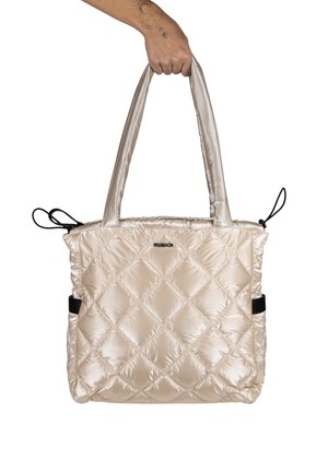 Bolso tote acolchado de color beige con acabado brillante, dos asas para el hombro y acentos en negro. Presenta un patrón de diamantes y cierres de cordón.