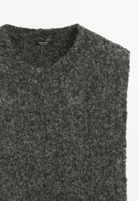 Dark gray knitted pullover with a crew neckline, a textured surface, and a loose fit. Label attached at the neck.