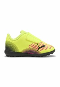 Pantofi de fotbal galbeni cu curea Velcro. Aceștia au linii grafice negre și roz și o talpă texturată neagră pentru aderență.