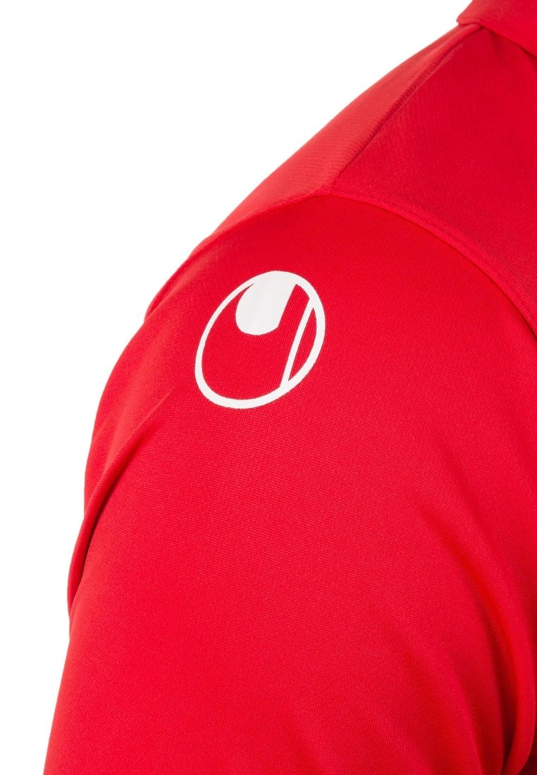 Camisa deportiva roja con una textura suave y un logo circular blanco en el hombro. El diseño es simple y ajustado.