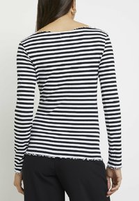  långärmad topp i svart och vitt randigt mönster, ribbad väv, rundad halsringning med fransiga kanter, figurnära design.