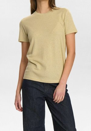 Kurzärmeliges, hellgelbes, geripptes T-Shirt aus weichem Stoff mit klassischem Rundhalsausschnitt und lockerem Schnitt. Kombiniert mit dunklen Jeanshosen.