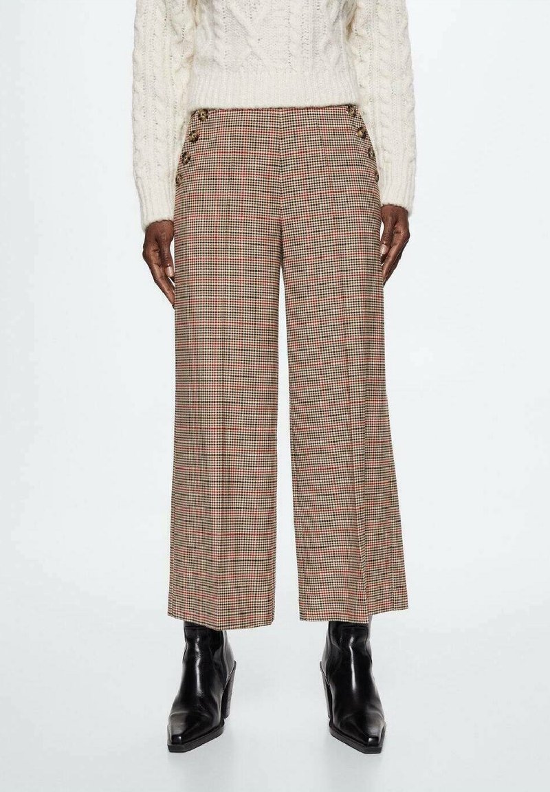 Geruite wijde broek in beige, rood en zwart; met zijknopen en een ontspannen pasvorm. De stof heeft een gladde textuur.