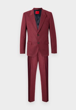 Burgundia ülikond, millel on struktureeritud bleiser, millel on kaks nuppu, sakilised kaelused ja sobivad püksid. Kanga tekstuur on sile.