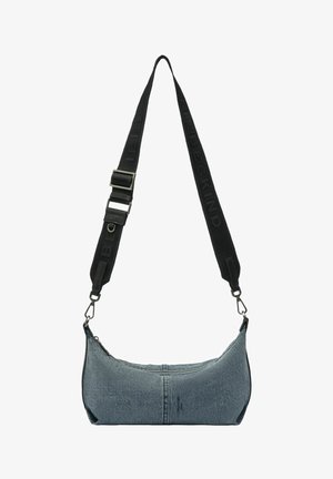 Sac d’épaule en denim en forme de croissant avec une bandoulière noire réglable, doté d’un logo embossé et de fermoirs métalliques argentés.
