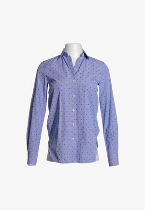 Camisa azul clara de manga larga con botones y pequeño patrón de cuadros rojos sobre un torso de maniquí blanco sobre fondo blanco.