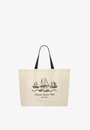 Beżowa torba typu tote z czarnymi uchwytami, z czarnymi liniowymi rysunkami trzech żaglówek i napisem „Ochnik Yacht Club est. 1989” poniżej.