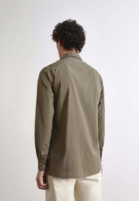 Olive green long-sleeve shirt with a grid pattern, buttoned cuffs, and a subtle collar, made from a lightweight fabric.