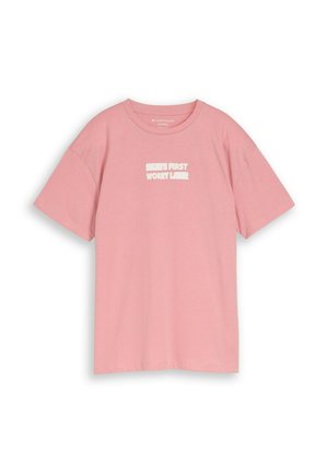 Roze katoenen T-shirt met korte mouwen en witte tekst "SKATE FIRST WORRY LATER" gedrukt op de borst.