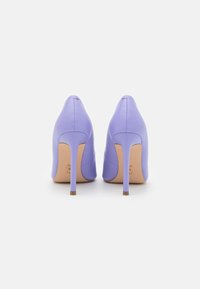 Purple leather high-heeled shoes with a pointed toe and a slender stiletto heel. The interior features a nude insole. Seam detailing is visible.