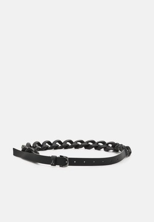 Zwarte leren riem met een gevlochten riemontwerp en metalen gesp die rust op een effen witte ondergrond.