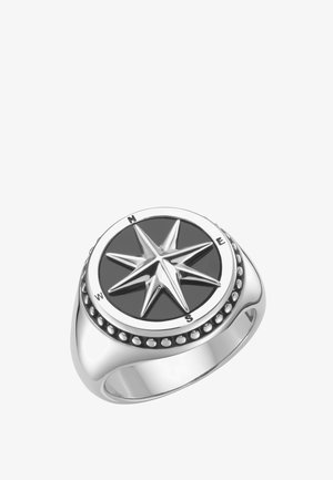 Silberner Ring mit einem erhabenen Kompassrosen-Design auf schwarzem Hintergrund, mit Markierungen für Norden, Osten, Süden und Westen auf dem Rand.