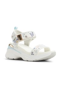 Hvide sandaler med blomstermønster i blå og brune nuancer, som har en tyk, tekstureret sål og justerbare stropper. Detaljer i guldtonet hardware.
