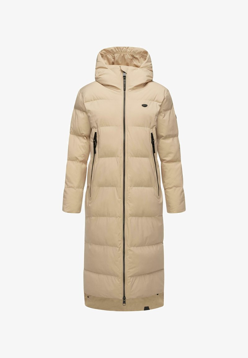 Beigā, līdz ceļgaliem garā pūkainā mētelī ar kapuci, ir bieza horizontāla pildījuma strukturēšana, priekšējā zipa aizdare un divas sānu kabatas. Gluda tekstūra.