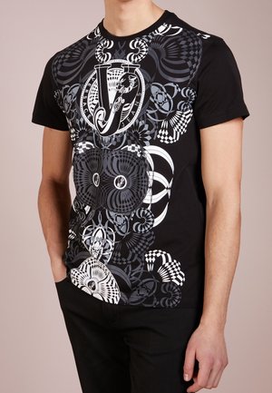 T-shirt noir avec un motif géométrique en spirale blanc et gris, affichant fièrement un logo au centre. Design à manches courtes et col rond.