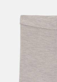 Grå tights gjorda av ett mjukt, strukturerat material med resårmidja och en slät yta. Inga mönster eller detaljer synliga.