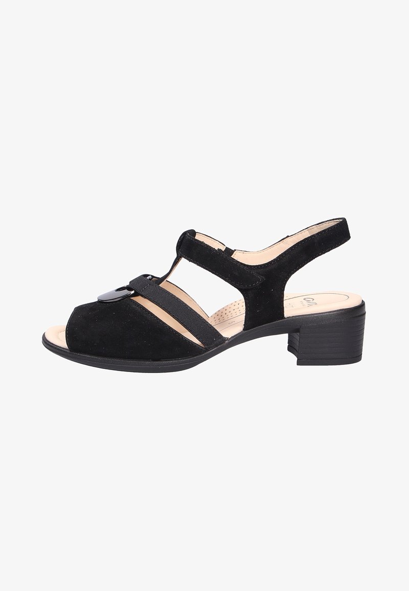 Sandal in suede nera con punta aperta, dettagli sulla fascia frontale e tacco a blocco di altezza media. Presenta bande elastiche per comodità e supporto.