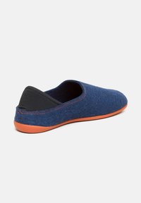 Scarpa blu in feltro senza lacci con un pannello posteriore nero e suola in gomma arancione. Presenta una forma arrotondata e cuciture a contrasto lungo i lati.