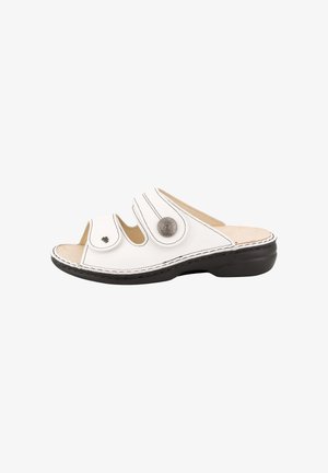 Witte open-teen slipper met twee verstelbare banden met zwarte stiksel en metallic knoopdetails op een zwarte zool.