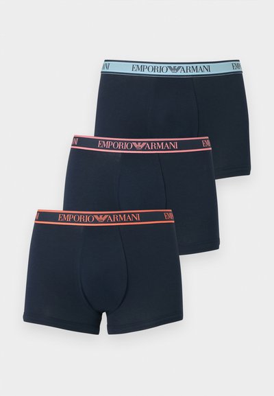 Τρία μαύρα ανδρικά εσώρουχα Emporio Armani σε στυλ μποξεράκια με αντίθετες μέσες σε αποχρώσεις ανοιχτού μπλε, ροζ και πορτοκαλί.