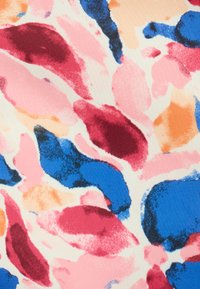 Tessuto con uno sfondo beige e motivi astratti in rosa, rosso, blu e arancione. Il design presenta forme morbide simili a pennellate.