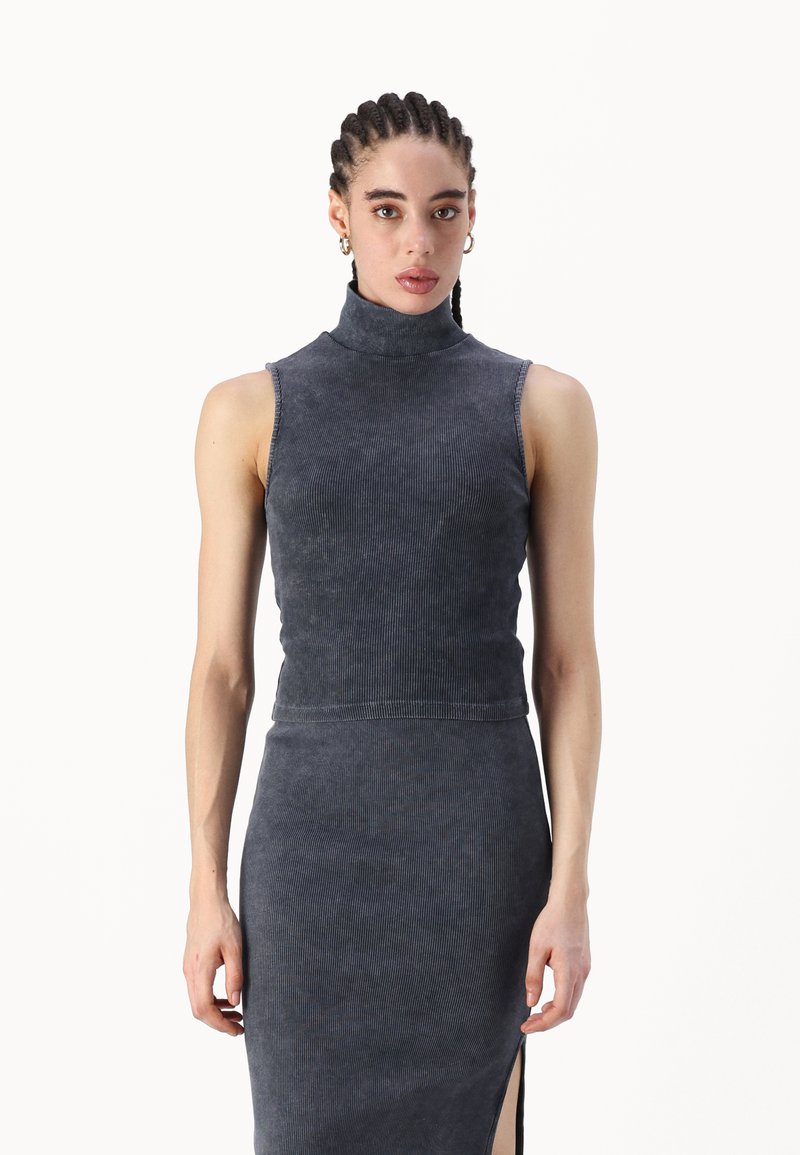 Top de gola alta canelado azul-escuro com um design justo. Apresenta um corte sem mangas, textura suave e um decote alto.