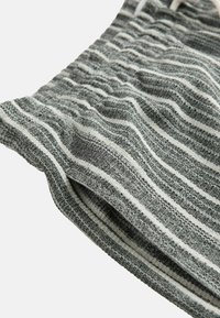 Gestrickte Stoffshorts in Grau mit weißen Streifen, ausgestattet mit einer strukturierten Oberfläche und einem elastischen Bund für zusätzlichen Komfort.