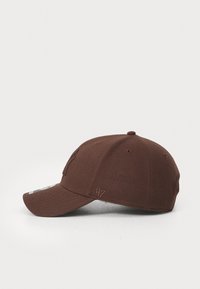 Brun hatt med en buet skygge, laget av teksturert stoff. Har et brodert logo på forsiden og et merke på siden.