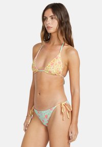Bikini set featuring a yellow floral triangle top with light blue accents and ties, paired with mint green floral bottoms with side ties.