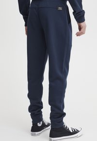 Navyblauwe joggingbroek van een katoenen mix, met een aansluitend ontwerp, zijzakken en elastische boorden bij de enkels.
