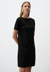 Zwart jurk met korte mouwen, een rechte silhouet, een gladde textuur en een ronde halslijn, met een eenvoudig ontwerp en zonder zichtbare patronen.
