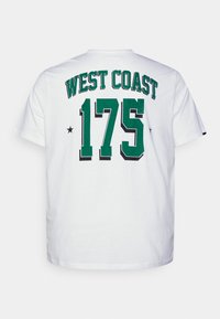 Camiseta de algodón blanca con letras verdes y negras: "COSTA OESTE" encima de "175," con estrellas negras a cada lado. Mangas cortas, cuello redondo.