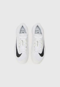 Biele športové topánky s textúrovaným zvrškom, čiernym logom Nike swoosh a bielymi šnúrkami. Navrhnuté na výkon, s odolnou podrážkou.