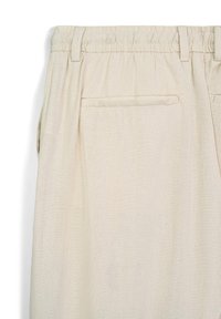 Pantaloni di lino beige con cintura elastica, dotati di tasca posteriore e tessuto morbido e texturizzato. Design semplice senza motivi visibili.
