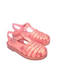 Pink jelly sandals with a woven design, adjustable buckles, and a glittery base. Made from transparent plastic with a glossy finish.