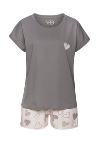 Pelēks īsām piedurknēm tops ar sirds dizainu uz krūšu daļas, kombinēts ar gaišiem šortiem, kuriem ir izkaisīti sirds raksti melnbaltā krāsā.