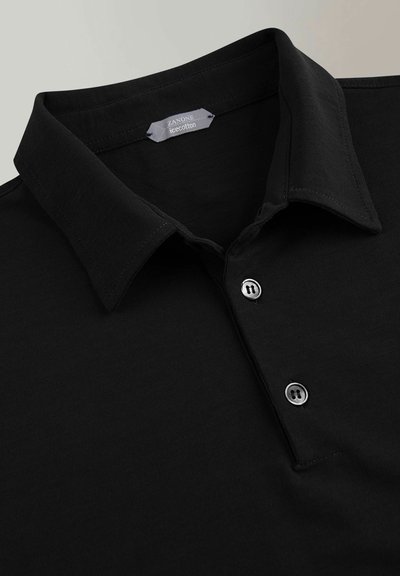 Camisa polo negra de algodón, con cuello y tres botones, y una textura suave. La etiqueta dice "Zanone Iecotton."