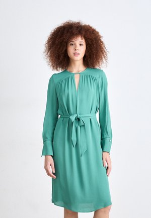 Green, long-sleeve dress with a keyhole neckline and tie waist. Made of smooth fabric, features buttoned cuffs and falls just above the knee.