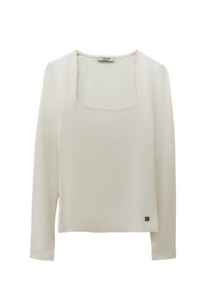Top beige a maniche lunghe con scollo quadrato e piccolo etichetta metallica del brand vicino all'orlo sul lato sinistro.